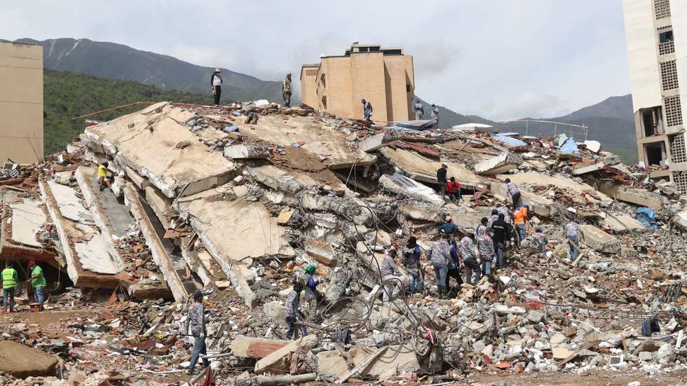 epa13076517 People work in search-and-rescue operations among the rubble of destroyed buildings in La Guaira, Venezuela, 30 June 2026. The death toll from two powerful earthquakes that struck northern Venezuela on 24 June has risen to at least 1,943, with 10,571 people injured, according to National Assembly President Jorge Rodriguez.  EPA/RAUL MARTINEZ