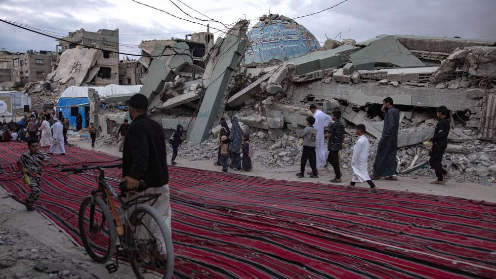 epa12996601 Displaced Palestinians gather to perform Eid al-Adha prayers beside the ruins of Al-Huda Mosque in Khan Younis, southern Gaza Strip, 27 May 2026. Eid al-Adha, also known as the Feast of Sacrifice, coincides with the annual Hajj pilgrimage to Mecca and is traditionally marked by the sacrifice of livestock and the distribution of meat among family, friends and those in need.  EPA/HAITHAM IMAD