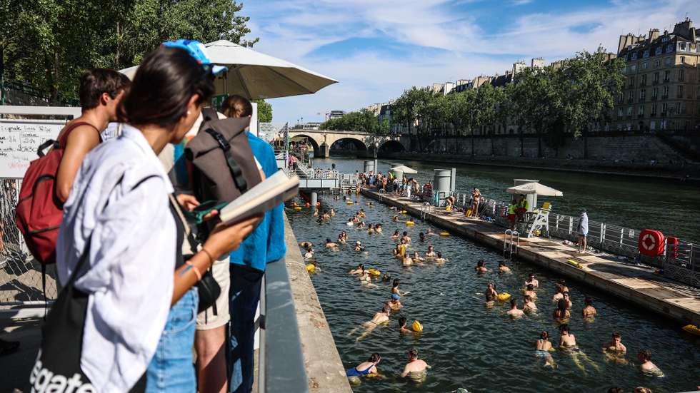 epa13105325 People swim next to the banks of the Seine during the heatwave in Paris, France, 11 July 2026.  EPA/MOHAMMED BADRA