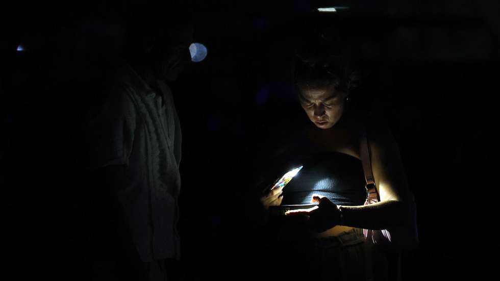 epa13146707 A person looks at a cell phone during a power outage in Havana, Cuba, 01 August 2026. Approximately 4.5 million Cubans, nearly half of the country's population, were left without electricity due to a failure in the National Electric System (SEN) that affected seven provinces from the western to the central region of the island.  EPA/Ernesto Mastrascusa