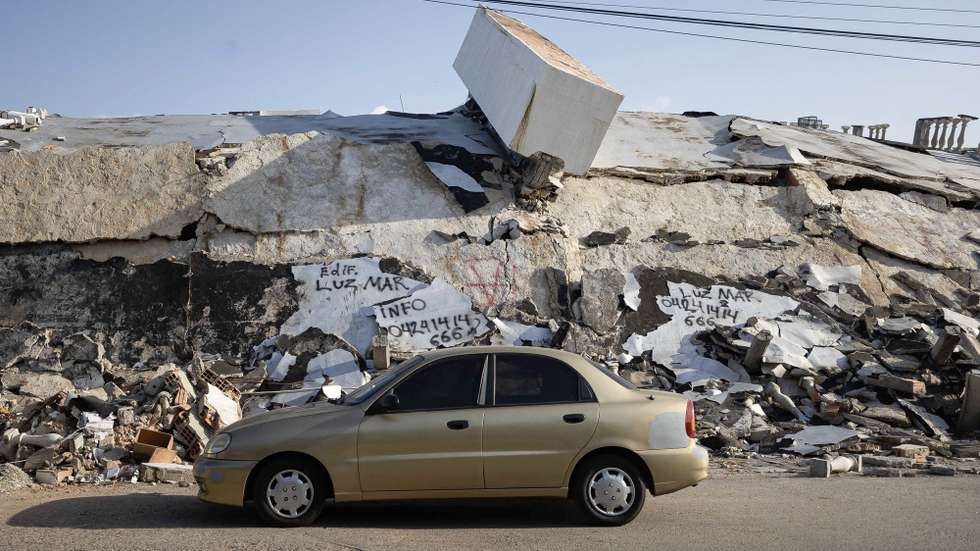 epa13138543 Photograph showing a vehicle in front of a building that collapsed due to the 7.2 and 7.5 magnitude earthquakes on June 24, which have caused extensive damage to homes, economic assets, businesses, and other types of structures, as well as loss of life the death toll of which is still being updated, in Catia La Mar, Venezuela, 28 July 2026.  EPA/Ronald Pena R