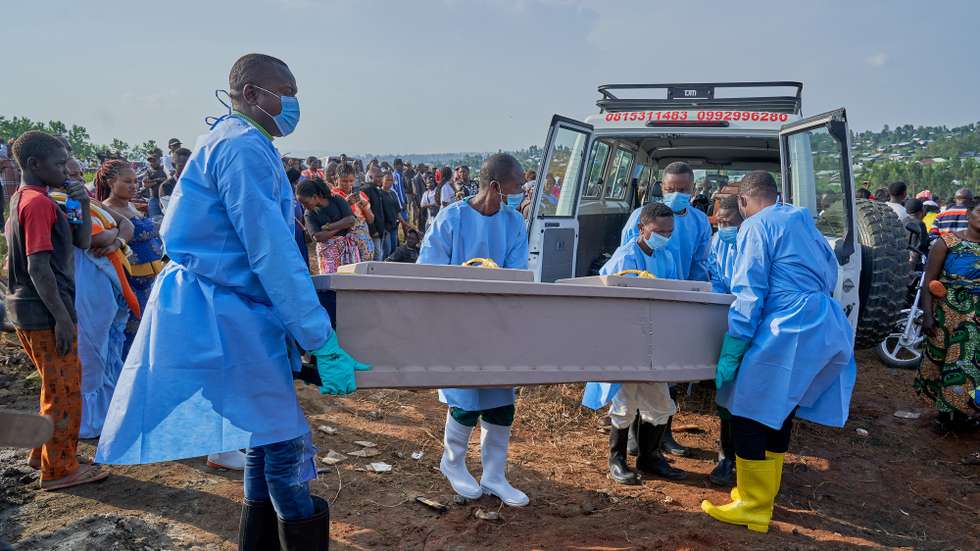 epa13127239 Staff prepare to bury the coffin of an Ebola victim in Bunia, Ituri province, Democratic Republic of Congo, 22 July 2026. According to the World Health Organization (WHO), the province of Ituri remains the epicenter of the Bundibugyo variant of the Ebola virus, reaching almost 1000 deaths.  EPA/DIEUDONNE DIROLE