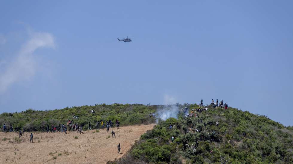 epa13171653 Sub-Saharan African and Sudanese migrants gather near Fnideq (Castillejos), Morocco, as they attempt to enter the Spanish city of Ceuta, 15 August 2026. Moroccan security sources said the attempted crossings took place in a mountainous area on the outskirts of Castillejos, southwest of Ceuta.  EPA/JALAL MORCHIDI