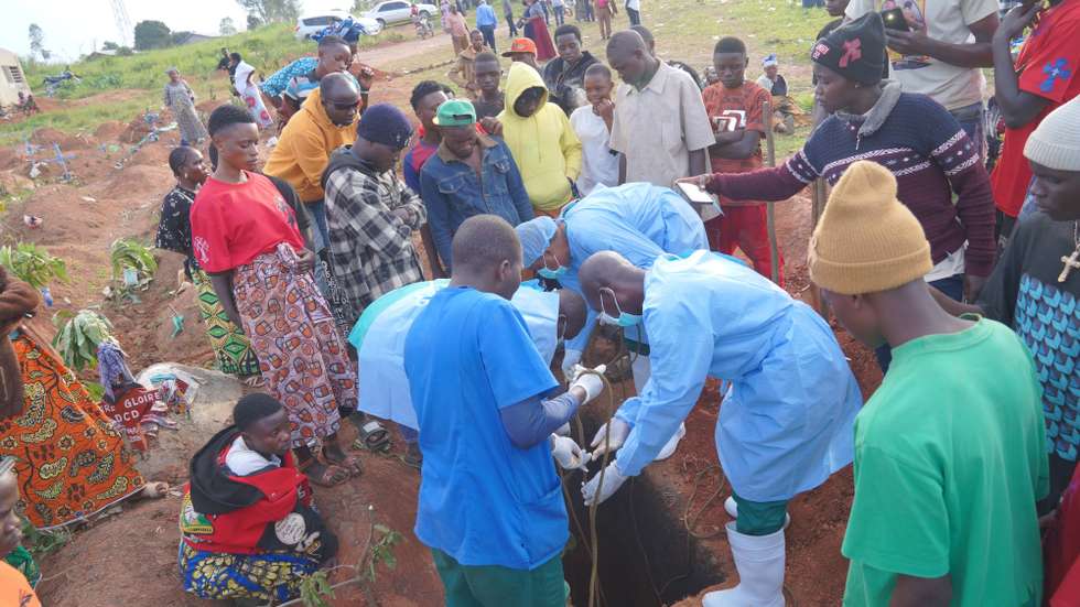 epa13177738 Members of the response team lower the body of Baudo Baraka Jules into a grave in accordance with Ebola burial protocols, in the presence of his family, in Bunia, Democratic Republic of the Congo, 18 August 2026. Jules died at the Ebola Treatment Center (ETC) northeast of Bunia after reportedly developing fever and vomiting, symptoms also experienced by his mother, while his father remains under observation at the same facility.  EPA/DIEUDONNE DIROLE