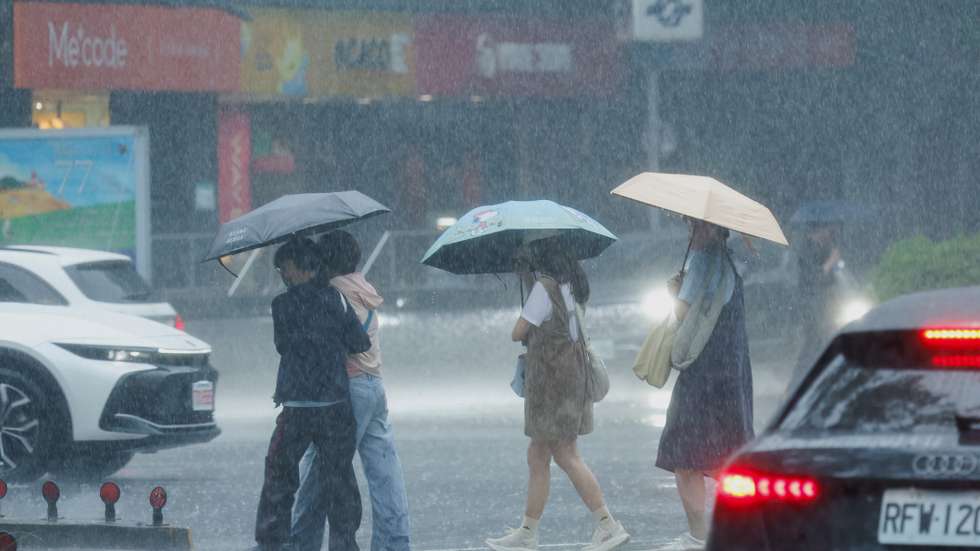 epa13156333 People cross a street during a downpour of rain brought by Typhoon Dolphin in Taipei, Taiwan, 08 August 2026. The Central Weather Administration reports that Typhoon Dolphin will pass closest to Taiwan between 08 August afternoon and 09 August while heading toward China. A land warning for Taiwan is now considered unlikely, and officials are monitoring the storm's potential impact on the Matsu Islands.  EPA/RITCHIE B. TONGO