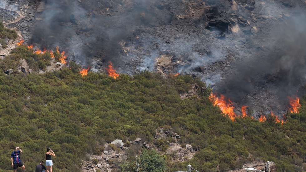 Populares observam o incêndio que consome mato, junto à povoação de Cando, na Serra da Freita, Arouca, 18 de agosto de 2026. PAULO NOVAIS/LUSA