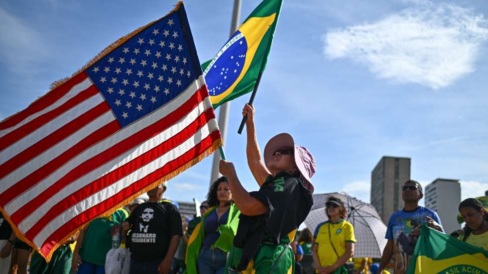 epa12560952 A supporter of former Brazilian President Jair Bolsonaro waves a US flag and a Brazilian flag during a protest against his imprisonment at the Esplanade of the Ministries government complex in Brasilia, Brazil, 30 November 2025.  EPA/ANDRE BORGES