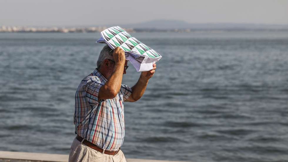 Um homem protege-se do calor com um saco de papel junto ao rio tejo esta tarde em Lisboa, 03 de setembro de 2026. distritos estão sob aviso amarelo hoje e amanhã devido à previsão e tempo quente, com valores elevados da temperatura máxima, segundo o Instituto Português do Mar e Atmosfera (IPMA). MIGUEL A. LOPES/ LUSA