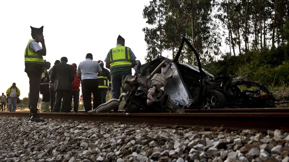 Bombeiros e elementos da GNR junto ao veículo colhido por um comboio de passageiros da Linha do Oeste junto à passagem de nível de Casal do Brejo, Caldas da Rainha 7 de julho de 2014. CARLOS BARROSO/LUSA
