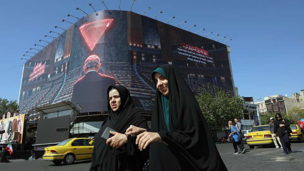 epa13298185 Iranian women walk near an anti-Israel billboard featuring Israeli Prime Minster Benjamin Netanyahu and a sentence reading in Persian 'Day by day isolated' at the Enghelab square  in Tehran, Iran, 12 October 2026. The conflict between Iran and the US continues.  EPA/ABEDIN TAHERKENAREH RESTRICTIONS: NO Access Israel Media/Persian Language TV Stations Outside Iran/Strictly No Access BBC Persian/VOA Persian/Manoto TV/Iran International TV. (As mandated by Iran's Directorate General for Foreign Media) --
