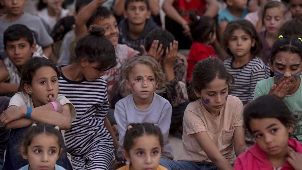epaselect epa13308021 Internally displaced Palestinian children watch a movie at a makeshift open-air cinema near the ruins of destroyed buildings in the Al-Sheikh Redwan neighborhood in Gaza City, 15 October 2026. Around 1.9 million people in Gaza, nearly 90 percent of the population, have been displaced since the Israel-Hamas conflict began in October 2023, according to the UN.  EPA/MOHAMMED SABER