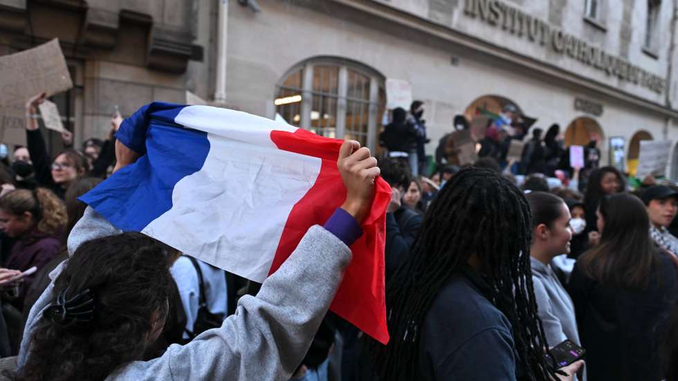 epa13288526 A student holds up a French national flag while demonstrating outside the Carmes campus of the Institut Catholique de Paris (ICP), in Paris, France, 08 October 2026. A wave of nationwide protests by high school students has been sweeping across France since late September 2026, later joined by university students, over severe teacher shortages, overcrowded lecture halls and classrooms, resource deficits, and poor learning conditions.  EPA/FIRAS ALTOUKHI