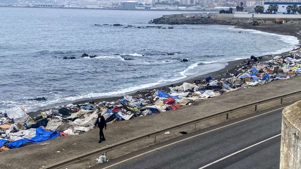 epa13282677 A person walks past the remains of a makeshift migrant encampment following a police operation to dismantle the camp on Trampolin beach in Ceuta, Spain, 05 October 2026. Trampolin Beach became the main informal settlement for migrants crossing into the enclave from Morocco since July 2026, sparking local tension and public safety concerns.  EPA/RAFAEL PENA