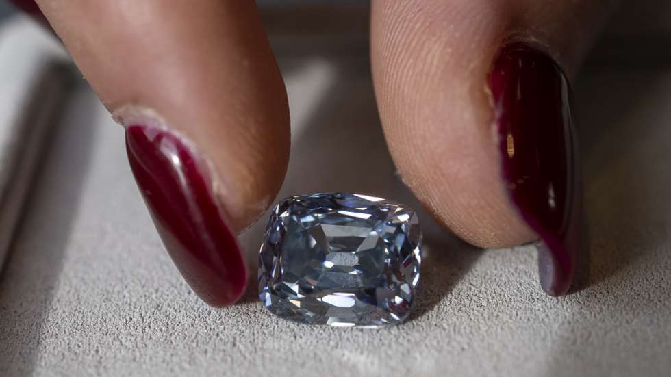 epa10283578 A Sotheby's employee displays a De Beers fancy vivid blue 5.53 carat diamond, during a preview at Sotheby's in Geneva, Switzerland, 03 November 2022. It is estimated to sell at 11,000,000 - 35,000,000 Swiss Francs. The auction will take place in Geneva on November 09.  EPA/MARTIAL TREZZINI