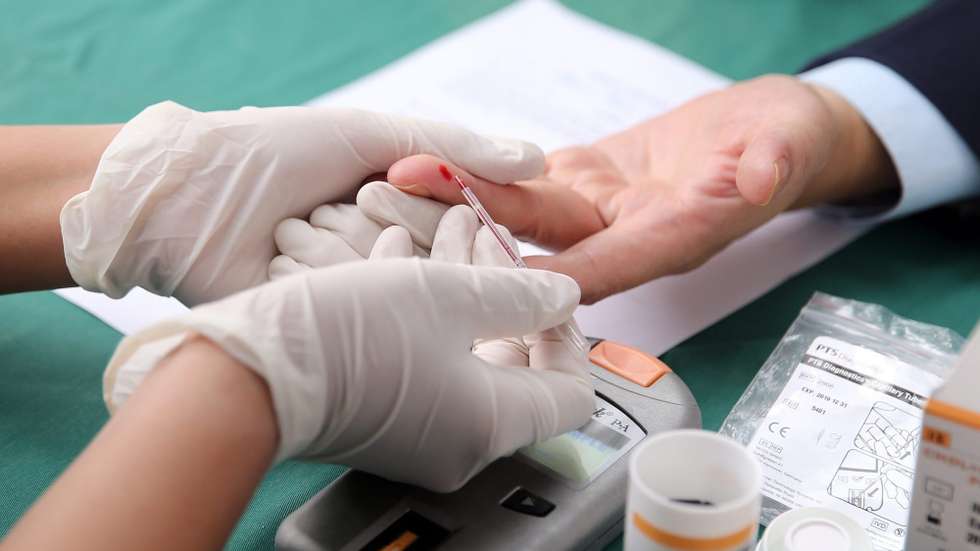 Um homem testa a glucose que tem no sangue