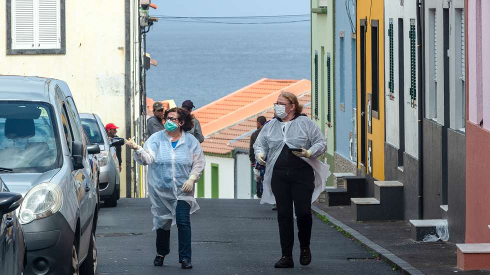 Duas assistentes socias durante a visita aos idosos que se encontram em quarente num dos bairros da vila de Rabo de Peixe, onde o porto de pesca continua em atividade, mesmo com as regras de confinamento devido à pandemia da covid-19, em Ribeira Grande, ilha de São Miguel, Açores, 07 de abril de 2020. Em Rabo de Peixe, a maior comunidade piscatória dos Açores, a população começa a cumprir as regras do confinamento, mas as ruas enchem-se de homens que continuam a ir ao mar. (ACOMPANHA TEXTO DO DIA 08 DE ABRIL DE 2020). EDUARDO COSTA/LUSA