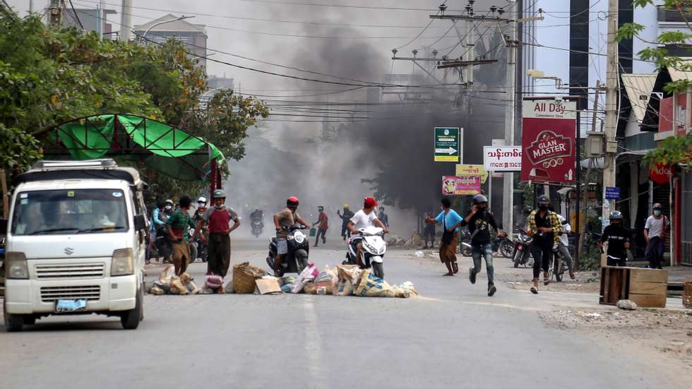 epa09087744 People flee during a protest against the military coup in Mandalay, Myanmar, 21 March 2021. Anti-coup protests continued despite the intensifying violent crackdowns on demonstrators by security forces.  EPA/STRINGER