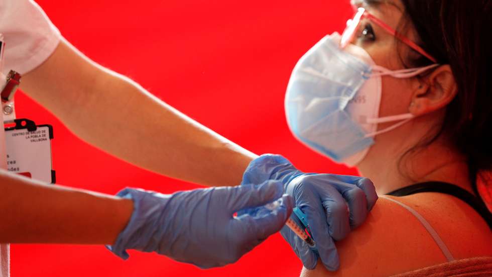 epaselect epa09099960 A health worker injects a dose of the AstraZeneca vaccine against COVID19 to a teacher, in Valencia, eastern Spain, 26 March 2021. Spain resumed the use of this vaccine after a 10-day-long pause in its administration after reports stated the vaccine could be associated with an increase in the risk of blood clotting disorders, doubts that were finally ruled out by the European Union's medicines regulator that declared the vaccine as safe.  EPA/Manuel Bruque