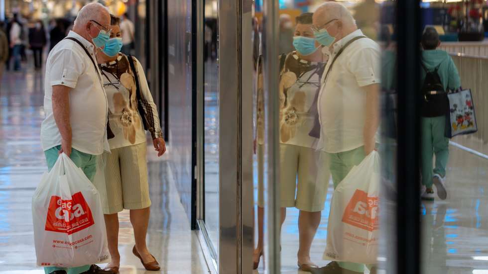 Pessoas observam as montras das lojas do Centro Comercial UBBO, no dia que marca o início da terceira fase de desconfinamento em Portugal, na Amadora, 19 de abril de 2021. Portugal inicia hoje a terceira fase do desconfinamento com a reabertura de mais escolas, lojas, restaurantes e cafés, um levantamento de restrições que não é acompanhado nos 10 concelhos onde a incidência da covid-19 é maior. JOSÉ SENA GOULÃO/LUSA