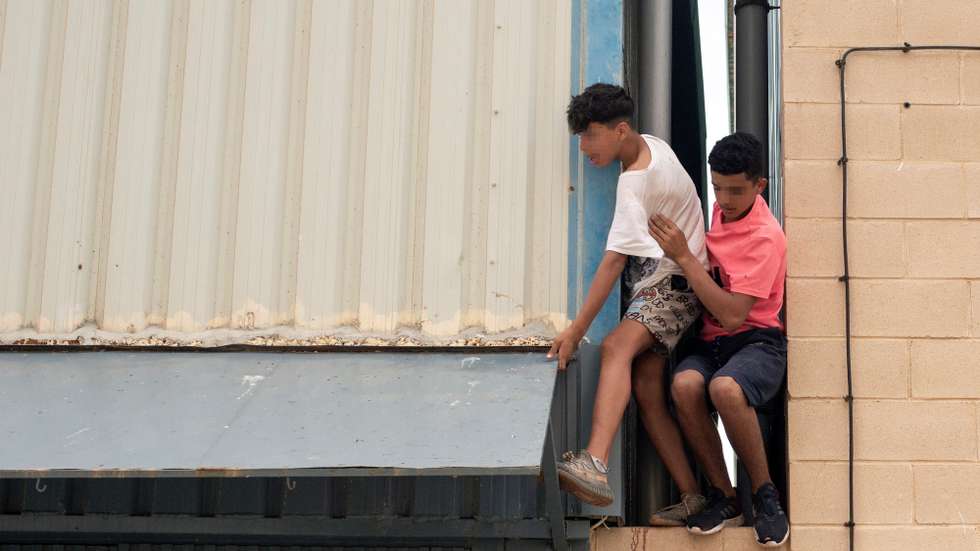 epa09218155 Two underage migrants escape from an industrial estate next to Tarajal beach, in the city of Ceuta, Spanish enclave in northern Africa, 21 May 2021. Local authorities reported that between 8,000-10,000 migrants managed to enter Spain from 18 to 19 May.  EPA/BRAIS LORENZO ATTENTION EDITORS: FACES PIXELATED AT SOURCE DUE TO LEGAL REQUIREMENTS
