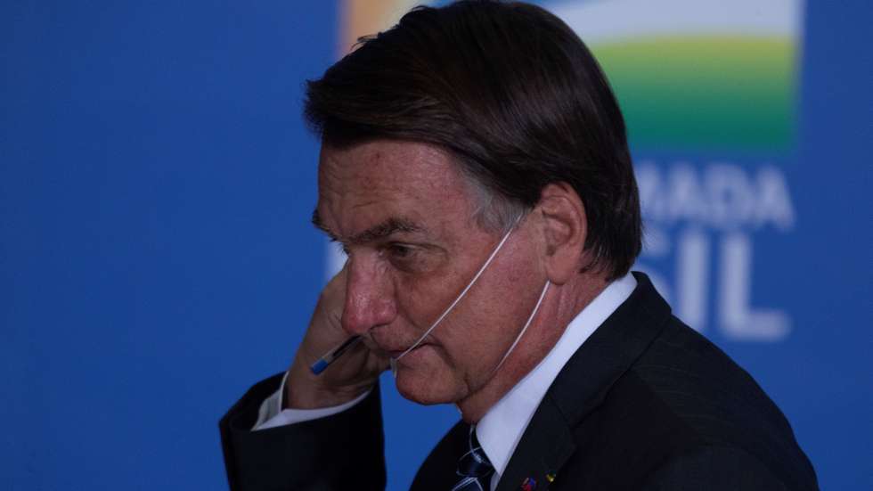 epa09294580 Brazilian President Jair Bolsonaro removes his face mask during the launching of an agriculture program at Planalto Presidential Palace in Brasilia, Brazil, 22 June 2021. Brazil's Goverment announced some US $50 billion for investments in agriculture during 2021-2022.  EPA/JoÃ©dson Alves