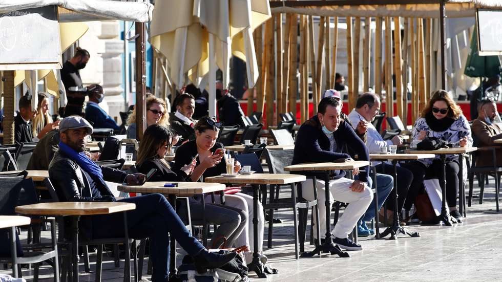 epa09210969 People drink a coffee during the reopening of terraces of restaurants and bars in Montpellier, France, 18 May 2021. France eases some of its coronavirus disease (COVID-19) restrictions starting on 19 May, allowing restaurants and cafes to admit customers outdoors, as pressure on hospitals and intensive care units in the country is diminishing.  EPA/GUILLAUME HORCAJUELO