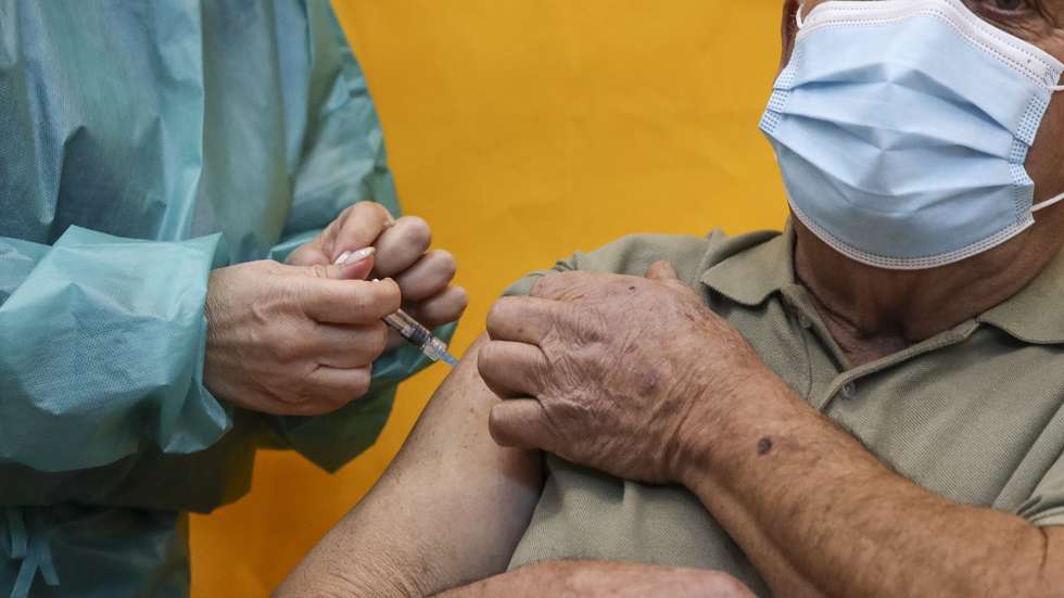 Um utentes é inoculado com uma dose de uma vacina por uma profissional de saúde no Centro de Vacinação de covid-19 de Coimbra que reabriu hoje, no Pavilhão Multidesportivo Dr. Mário Mexia, em Coimbra, 23 de novembro de 2021. PAULO NOVAIS/LUSA