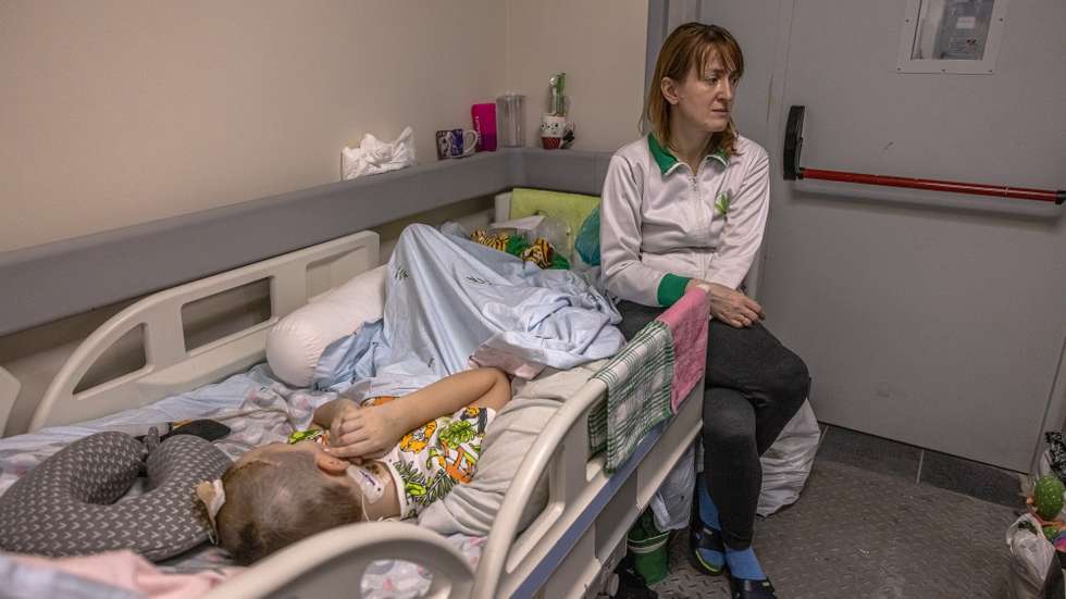 epa09794371 A woman sits next to a child being treated at the in Ohmadyt children's hospital basement used as a shelter for protection against airstrikes, in Kyiv (Kiev), Ukraine, 01 March 2022. Russian troops entered Ukraine on 24 February prompting the country's president to declare martial law and triggering a series of severe economic sanctions imposed by Western countries on Russia.  EPA/ROMAN PILIPEY
