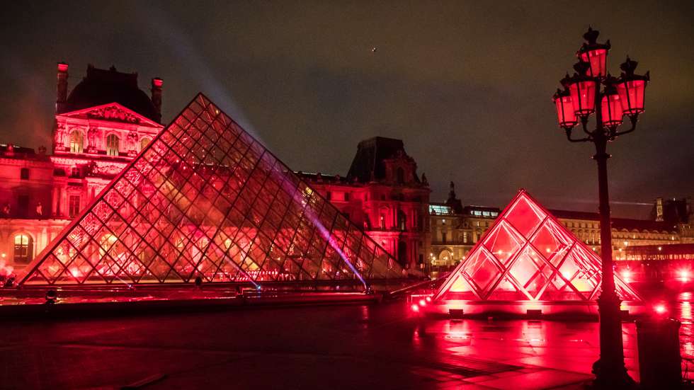 epa08910941 Lights are projected on the Louvre's Museum Pyramid during the tuning of the performance of the French Dj David Guetta in Paris, 29 December 2020 (issued 30 December 2020). The third edition of the Guetta's 'United at Home' concert will be broadcasted 31 December for the New Year Eve celebration on social media and TV. Due to the still high number of Covid-19 cases, a curfew is imposed between 8 pm and 6 am effective from 15 December 2020 and all the streets gathering or celebrations are cancelled.  EPA/CHRISTOPHE PETIT TESSON