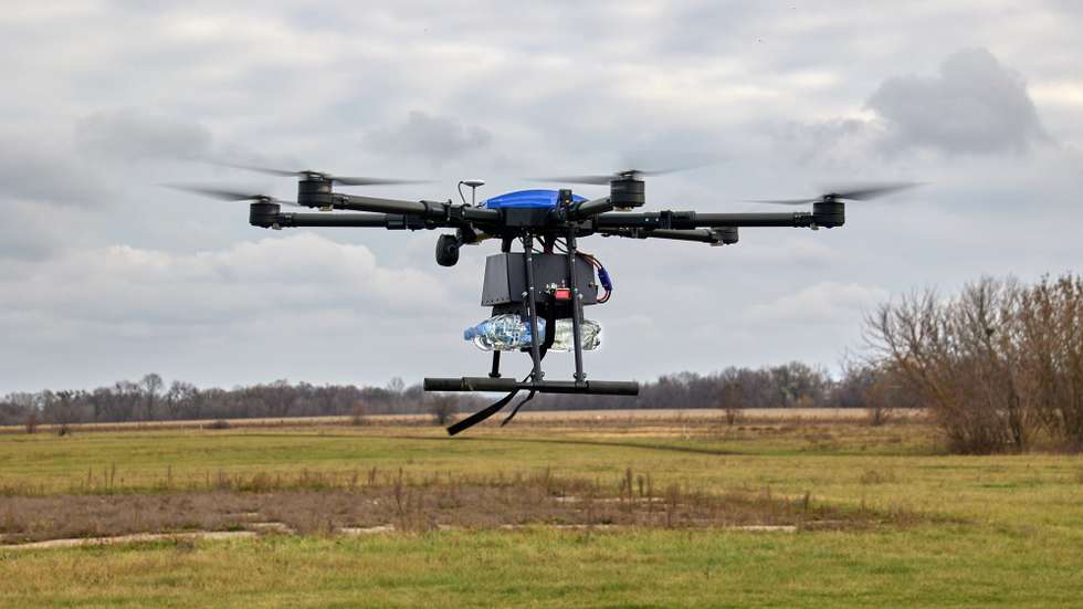 epa10286422 A drone carrying bottles of water that imitate explosive items flies during a training of Ukrainian volunteer unit Khartiia who are learning how to operate drones, in a field near Kharkiv, Ukraine, 04 November 2022. Russian troops entered Ukrainian territory on  24 February, starting a conflict that has provoked destruction and a humanitarian crisis.  EPA/SERGIY KOZLOV