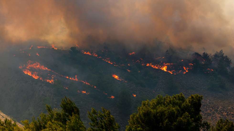epa10766540 A fire burns trees and low vegetation in the Malona area of ​​Rhodes, Greece, 24 July 2023. The fire brigade and volunteers are fighting to prevent the fire from entering the villages of Gennadi and Vati, in southern Rhodes. Several fire engines and volunteers have rushed to the area, while water is being thrown from firefighting planes. A while ago, by order from 112, it was decided to evacuate both villages. The battle continues in Asclepion.  EPA/LEFTERIS DAMIANIDIS
