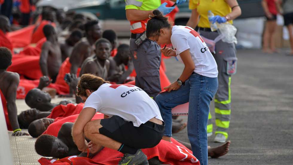 epa10900563 Emergency services attend to the 69 occupants of the last of the five cayucos (boats) that arrived in the municipality of El Pinar, Spain, 04 October 2023. Five boats, the largest with 271 people on board, bringing more than 500 migrants have landed in El Hierro on 04 October, according to Maritime Rescue.  EPA/Gelmert Finol