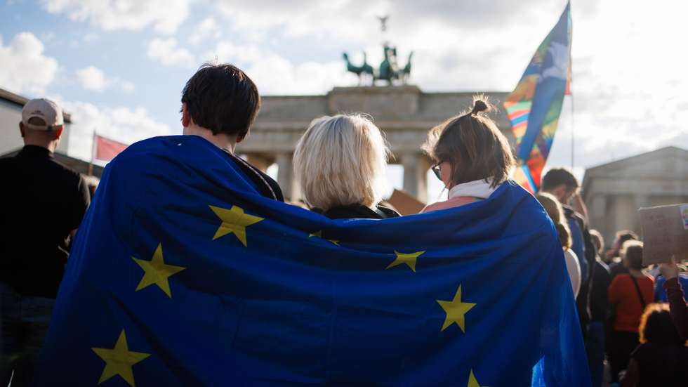 epa11320465 Participants hold a European Union flag, wrapped around their shoulders, during a rally in reaction to attacks on campaigning politicians in Germany, in Berlin, Germany, 05 May 2024. The rally was held after Saxony Social Democratic Party's (SPD) top candidate for the upcoming European elections and Member of the European Parliament, Matthias Ecke, was attacked by a small group of people, on 03 May 2024, during the process of installing campaign posters.  EPA/CLEMENS BILAN