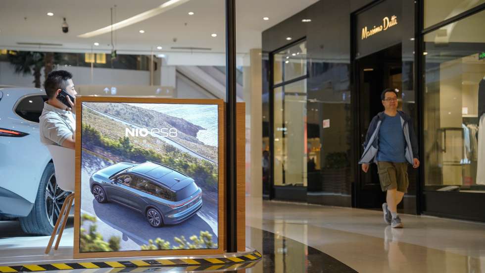 epa11407062 A man walks beside a NIO ET5 electric car on display in a shopping mall in Beijing, China, 13 June 2024. Beijing urges the European Union to reconsider tariffs on Chinese electric vehicles and to stop going further in what they say is the 'wrong direction' to protect its auto industry from competition, according to China's state news agency Xinhua. China said it would take measures to safeguard its interests after the European Commission announced on 12 June it would impose extra duties of up to 38.1 percent on imported Chinese electric vehicles from July 2024.  EPA/WU HAO