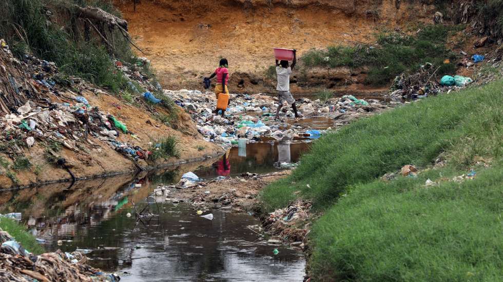 Habitantes atravessam uma enorme vala onde se acumulam detritos e águas paradas no Bairro Paraíso, conhecido pelos níveis elevados de pobreza e criminalidade, a doença e a morte vieram afligir ainda mais os moradores, em Luanda, 09 de janeiro de 2025. Pelo menos cinco pessoas foram oficialmente proclamadas vítimas de cólera, doença ligada à contaminação fecal associada à falta de saneamento e tratamento de água e má higiene, e os habitantes estão preocupados pedindo a intervenção das autoridades angolanas. (ACOMPANHA TEXTO DA LUSA DO DIA 12 DE JANEIRO DE 2025). AMPE ROGÉRIO/LUSA