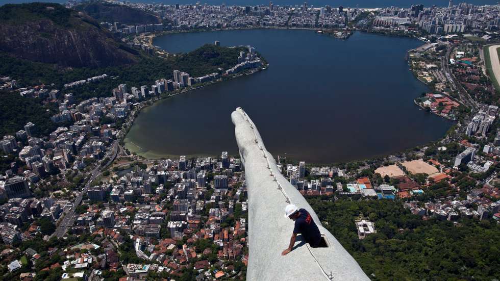 epa04034958 A worker reviews an arm of the sculpture Cristo Redentor in Rio de Janeiro, Brazil, 21 January 2014. The works of maintenance and recovery of the monument began on 21 January after it was affected by several lightning bolts during the previous week.  EPA/ANTONIO LACERDA