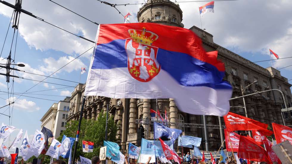 epa12067441 A man waves a Serbian flag during the International Workers' Day rally in Belgrade, Serbia, 01 May 2025. Labor Day, or May Day, is observed worldwide on 01 May to celebrate the economic and social achievements of workers as well as fight for laborers' rights.  EPA/ANDREJ CUKIC