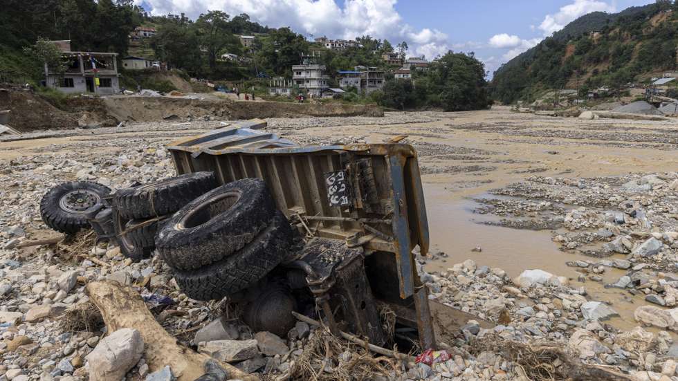 epa11635325 A damaged vehicle is seen at the bank of Nallu River after the deadly flood at Tika Bhairav, Lalitpur district, Nepal, 01 October 2024. More than 200 people are dead, thousands of homes were destroyed, due to the floods and landslides in Nepal, according to the police. The Prithvi Highway, a major route connecting the capital, Kathmandu, with outer districts of Nepal, has been blocked in multiple places by landslides. More than 20 hydropower plants were damaged due to the deadly landslides and floods that occurred across Nepal following torrential rainfall on 28 September 2024, according to the National Disaster Risk Reduction and Management Authority.  EPA/NARENDRA SHRESTHA