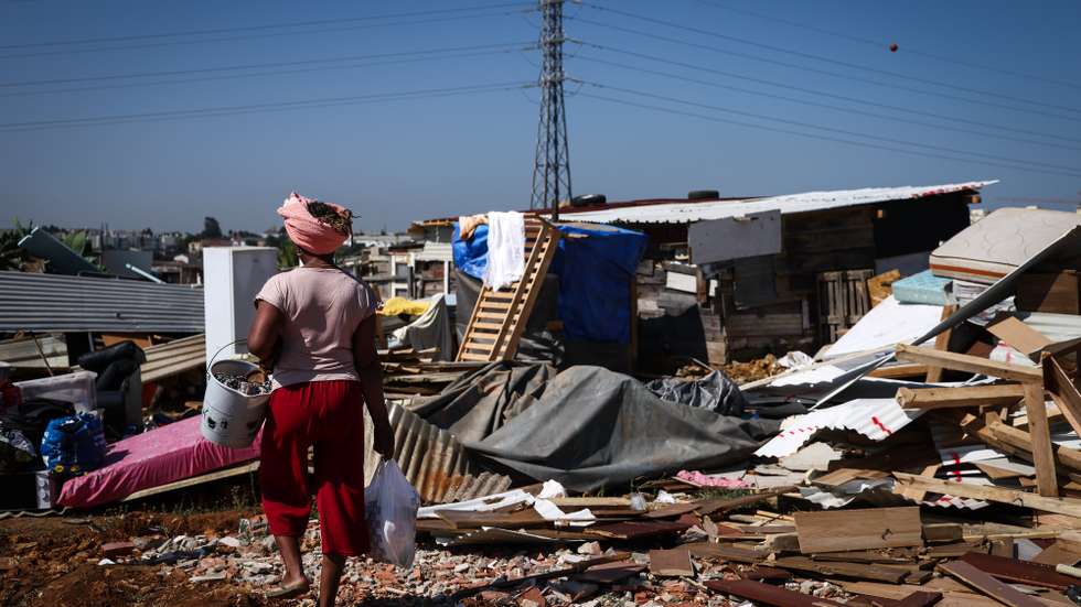 Uma moradora passa por destroços das habitações demolidas, durante o segundo dia da operação de demolição de habitações no bairro do Talude, uma ação da Câmara Municipal de Loures, em Loures, 15 de julho de 2025. O Tribunal Administrativo de Círculo de Lisboa decretou que a Câmara Municipal de Loures fica “impedida de executar o ato de demolição” de habitações no Bairro do Talude Militar, segundo um despacho de segunda-feira à noite consultado pela agência Lusa. RODRIGO ANTUNES/LUSA