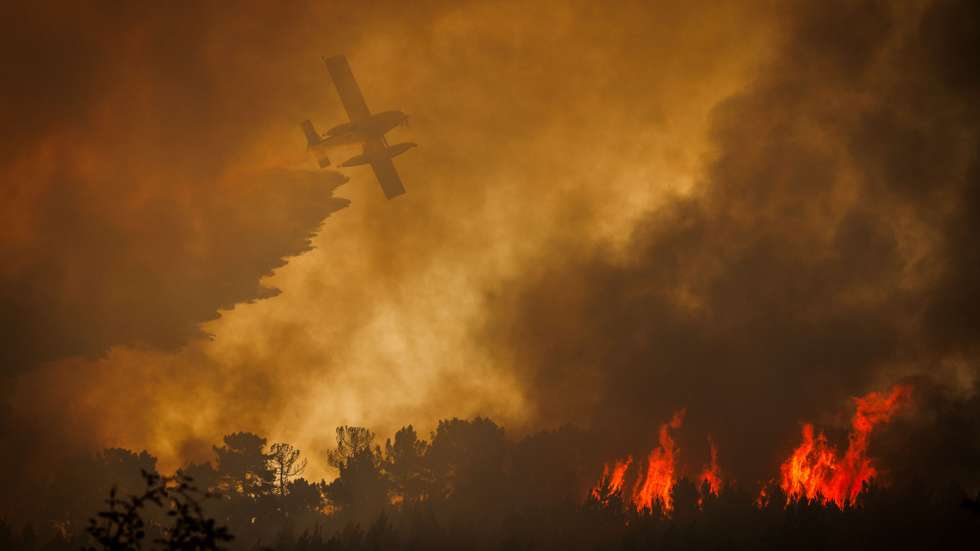 Um avião faz uma descarga de água no combate um incêndio em Sabrosa, Vila Real, 16 de julho de 2025. O vento forte e irregular que provoca várias projeções está a dificultar o combate ao incêndio que lavra em Souto Maior, Sabrosa, e que pelas 20:50 mobilizava 349 operacionais, 107 meios terrestres e 1 meio aéreo, segundo a página da ANEPC - Autoridade Nacional de Emergência e Proteção Civil. PEDRO SARMENTO COSTA/LUSA