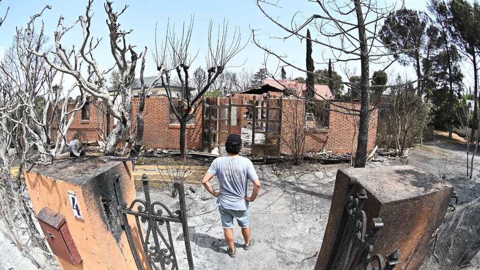 epa12295619 A local man stands near a damaged building at an area affected by a fire in Tres Cantos, near Madrid, Spain, 12 August 2025. A 50 year-old man died from his injuries after a wildfire forced the evacuation of three housing estates in the Tres Cantos area on 11 August.  EPA/FERNANDO VILLAR