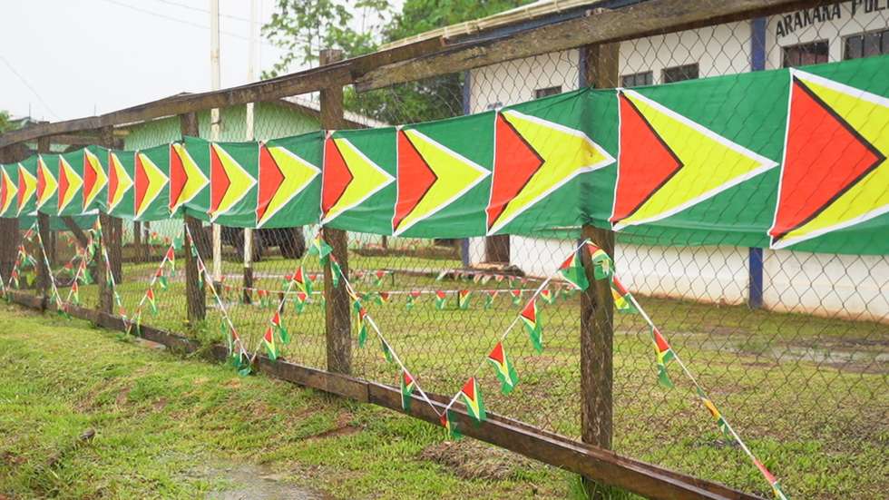 epa12135911 Guyanese flags line a fence in front of a police station in the village of Arrakaka, Esequibo, Guyana, 25 May 2025. Guyana defends the validity of the Paris Arbitral Award of 1899, which gave territory sovereignty to the then-British Guyana. Furthermore, it insists that the International Court of Justice (ICJ) has jurisdiction to resolve this dispute, which Venezuela rejects.  EPA/NAZIMA RAGHUBIR