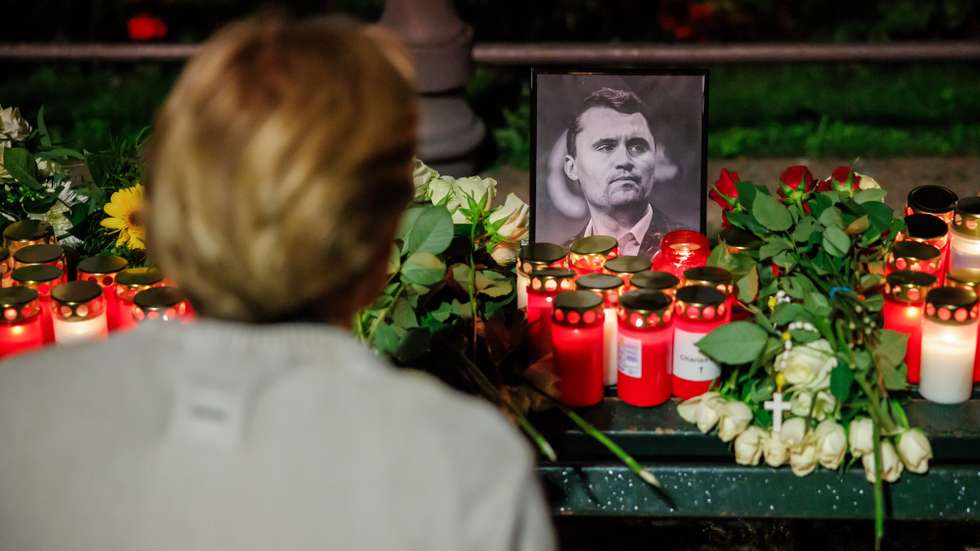 epa12370143 A person looks at a photo of the deceased US political activist Charlie Kirk during a vigil in reaction to his assassination, in Berlin, Germany, 11 September 2025. Kirk was shot dead on 10 September at an event he was hosting at Utah Valley University. The vigil was held near the Brandenburg Gate in front of the US embassy.  EPA/CLEMENS BILAN