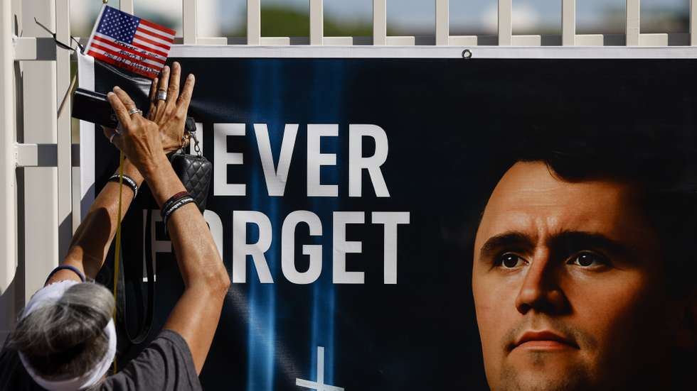 epa12393504 A person places an American flag at a makeshift memorial for conservative political activist Charlie Kirk outside the Turning Point USA headquarters in Phoenix, Arizona, USA, 20 September 2025. A memorial service for Kirk is scheduled to take place on 21 September in Glendale, Arizona.  EPA/CAROLINE BREHMAN