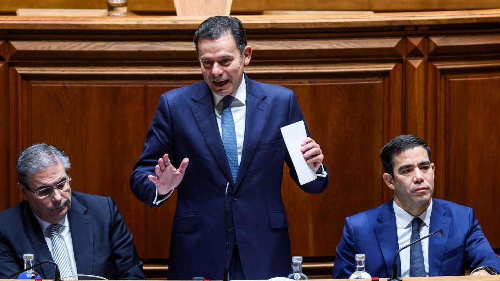 O primeiro-ministro, Luis Montenegro, ladeado por Carlos Abreu Amorim (E), ministro dos Assuntos Parlamentares, e por António Leitão Amaro (D), ministro da Presidência, usa da palavra durante o debate parlamentar na Assembleia da República em Lisboa, 5 de dezembro de 2025. TIAGO PETINGA/LUSA