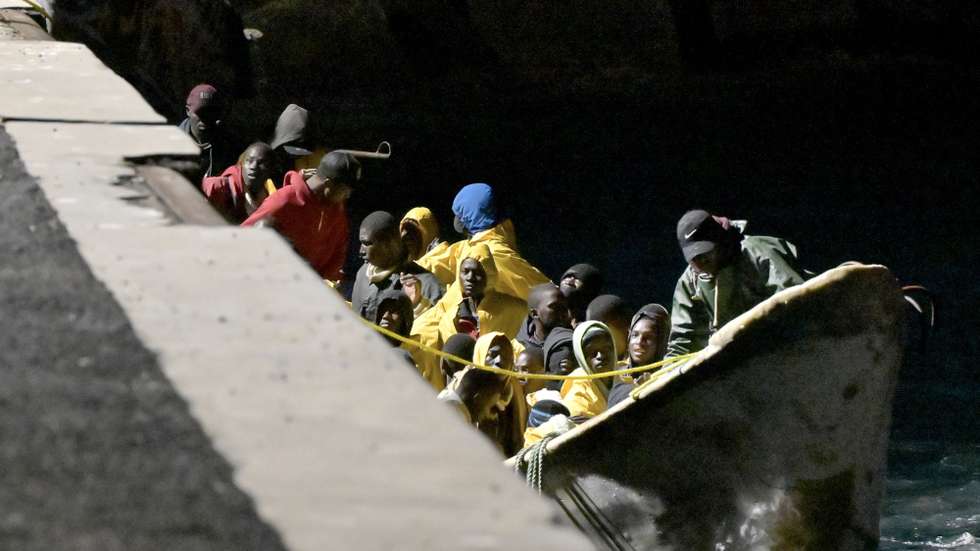epaselect epa11049171 A view shows migrants, part of a group of 62 migrants rescued by the maritime rescue vessel 'Salvamar Polimnia', sitting in a wooden canoe ('cayuco') upon their arrival at the port of La Restinga, in the municipality of El Pinar, El Hierro island, Canary Islands, Spain, 30 December 2023. Two new canoes arrived late on 29 December to the island of El Hierro with a total of 181 people on board - 119 in the first boat rescued, and 62 people in the second, according to the emergency teams. The island of El Hierro, the smallest of the Canary Islands with a population of about 11,700 inhabitants, has received a total of 14,951 migrants in cayucos since May 2023, including 3,654 minors and 633 women, a figure that exceeds, the number of people who reached Spain in 2023 through the Mediterranean route until mid-December, according to data collected by the emergency teams.  EPA/GELMERT FINOL