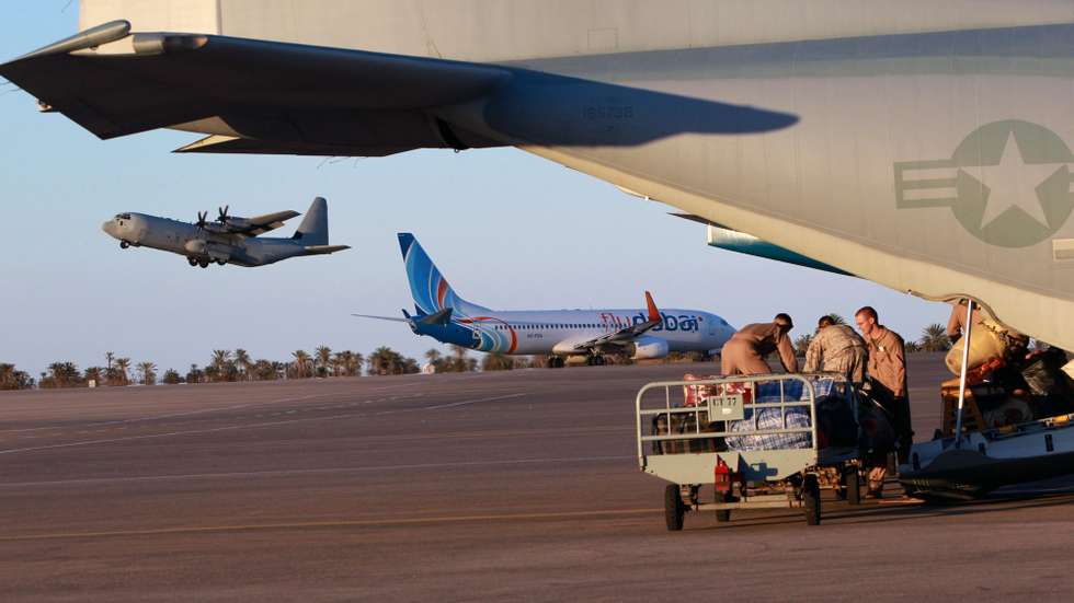 epa02617161 US Marines load luggage of Egyptian nationals who fled Libya recently on a US Marine C-130 transport plane on the runway in Djerba Airport in Tunisia, on 05 March 2011. The US Marines flew at least two C-130 planes filled with Egyptians back to Cairo on 05 March night as they assist in the repatriation effort for the thousands who fled Libya. The planes are part of the 26th MEU (Marine Expedition Force), and come from a US base in Sigonella, Sicily, Italy.  EPA/JIM HOLANDER