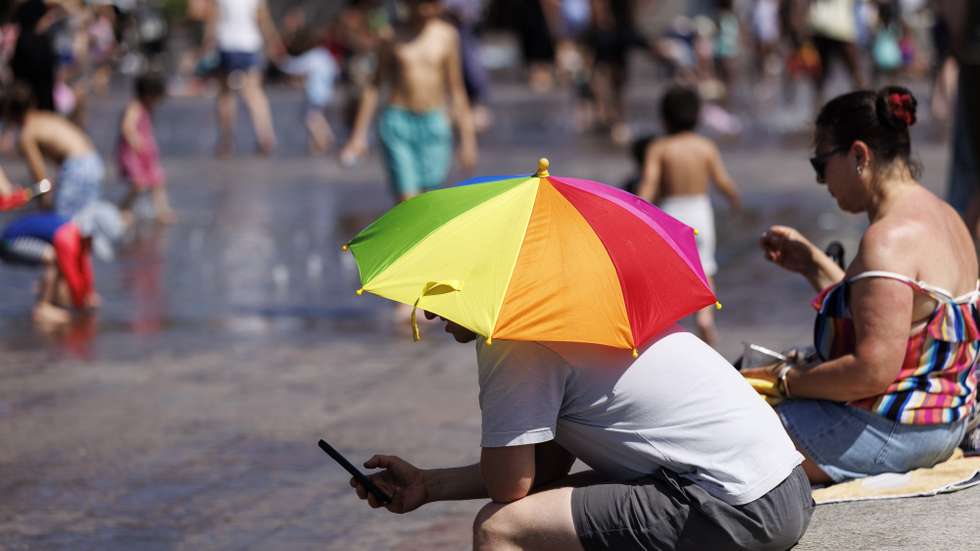 epa12995286 A person uses an umbrella to shelter from the sunshine at Granary Square during a heatwave in London, Britain, 26 May 2026. The record for the hottest May day on record in the UK is broken again with 35 Celsius degrees recorded in London during the heatwave. The UK Health Security Agency has issued an amber heat health alert for south-west England, bringing the number of amber alerts during the heatwave to six.  EPA/TOLGA AKMEN