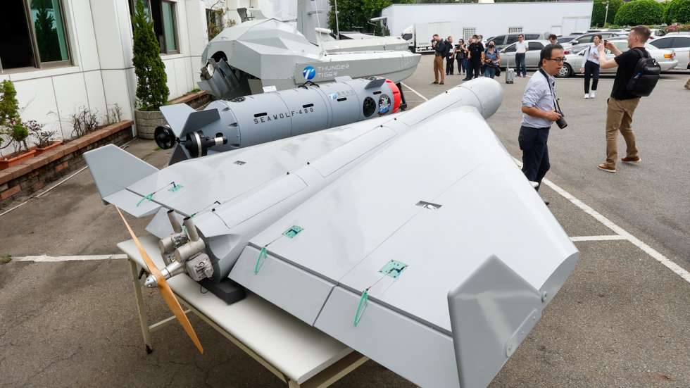 epa12904086 Journalist observe the suicide drone (front) with other UAV models during a press tour in Taichung, Taiwan, 21 April 2026. Thunder Tiger Corporation is a Taiwanese company that designs and manufactures defense-oriented unmanned vehicles, including UAVs (such as the T-400, TM-450, and Blackhawk T-235), unmanned surface vessels (SeaShark USV), underwater ROVs, and all-terrain ground vehicles, with additional disaster-response collaborations in Taiwan.  EPA/RITCHIE B. TONGO