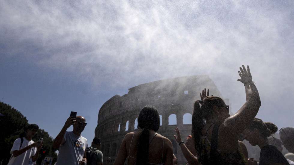 epa13066140 People cool off amidst water misters installed near the Colosseum during high temperatures in Rome, Italy, 26 June 2026.  EPA/MASSIMO PERCOSSI